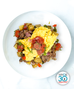 A plate of Beef Barbacoa and Scrambled Eggs With Potato Hash And Roasted Pico De Gallo