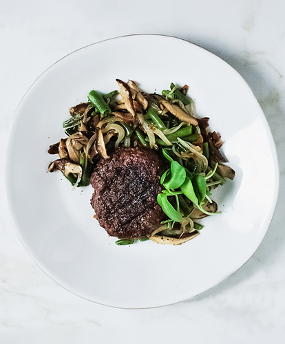 A plate of a Beef Burger with Green Bean Salad
