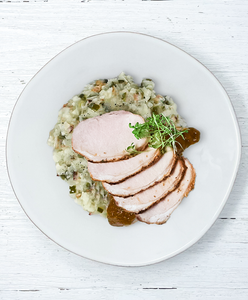 A plate of Pork Loin with Peach BBQ Sauce and Bacon Jalapeno Cauliflower Risotto